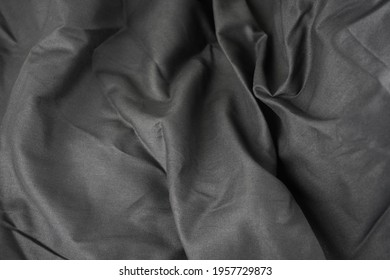 The creases on the black fabric that the light shines through.