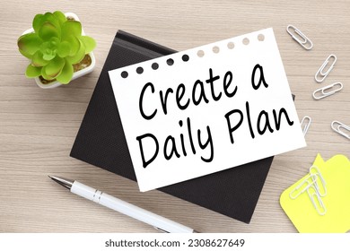 create a daily plan. text on white page on black notepad - Shutterstock ID 2308627649