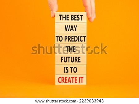 Create future symbol. Concept words The best way to predict the future is to create it on wooden blocks. Beautiful orange background copy space. Businessman hand. Business create your future concept.
