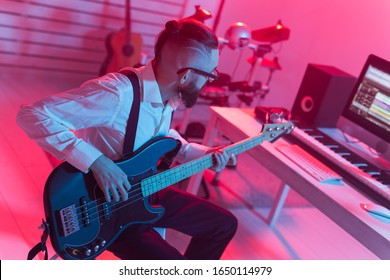 Create Music And A Recording Studio Concept - Bearded Funny Man Guitarist Recording Electric Bass Guitar Track In Home Studio