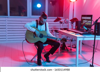 Create music and a recording studio concept - Bearded man guitarist recording electric guitar track in home studio - Powered by Shutterstock