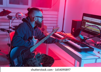 Create Music And A Recording Studio Concept - Bearded Funny Man Guitarist Recording Electric Bass Guitar Track In Home Studio