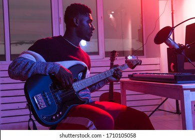 Create Music And A Recording Studio Concept - African American Man Guitarist Recording Electric Bass Guitar Track In Home Studio