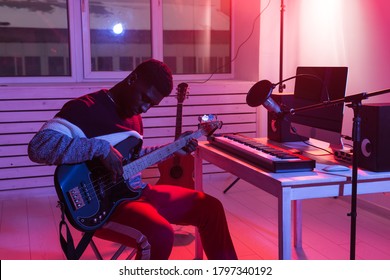 Create Music And A Recording Studio Concept - Black Man Guitarist Recording Electric Bass Guitar Track In Home Studio