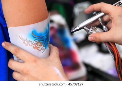 Creating An Air Brush Tatoo On A Youn Gilrs Arm