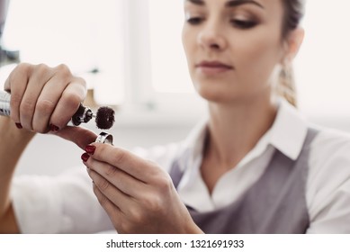 Creating a beauty. Close-up portrait of young female jeweler preparing polishing tool for making jewelry.