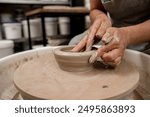 Creating a ceramic bowl by yourself in a pottery class. Wheel throwing. Learning how to model clay into different shapes with pottery wheel