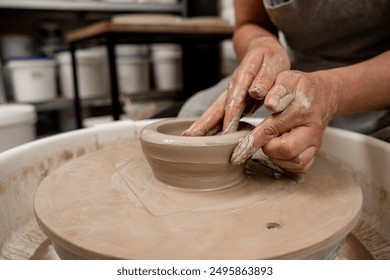 Creating a ceramic bowl by yourself in a pottery class. Wheel throwing. Learning how to model clay into different shapes with pottery wheel - Powered by Shutterstock