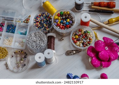 Creating Christmas ornaments. Handcraft artist workspace. Laptop, colorful beads, felt, tools, scissors, needles, thread spools, glue, containers, pliers, wire. Creative chaos concept. Flat lay. - Powered by Shutterstock