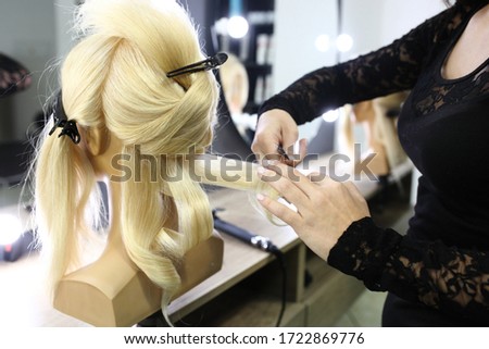 Creating hairstyles on a mannequin. Training hair styling on a mannequin.