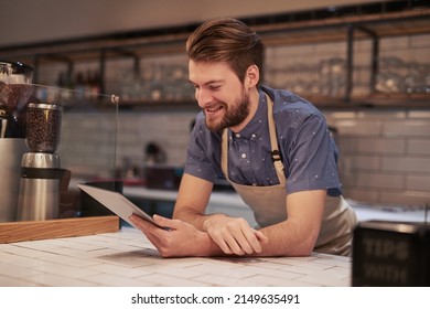 Creating inexpensive online advertisements to target local audiences. Shot of a young man using a digital tablet while working in a coffee shop. - Powered by Shutterstock