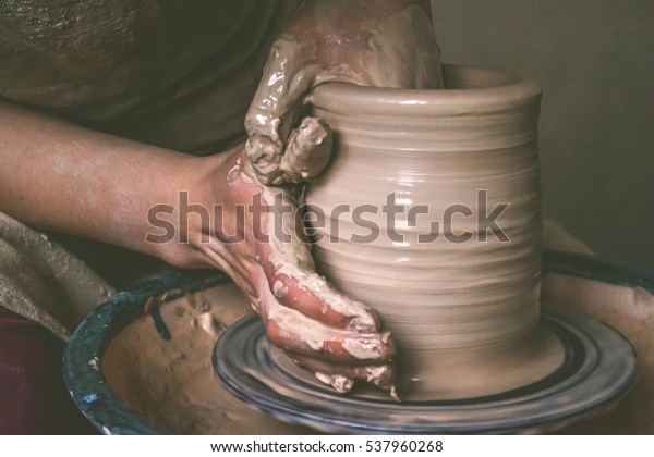 Creating\
a jar or vase of white clay close-up. Master crock. Man hands\
making clay jug macro. The sculptor in the workshop makes a jug out\
of earthenware closeup. Twisted potter\'s\
wheel.