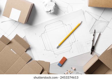 Creating packaging design. Drawings, boxes and stationery on light wooden table, flat lay