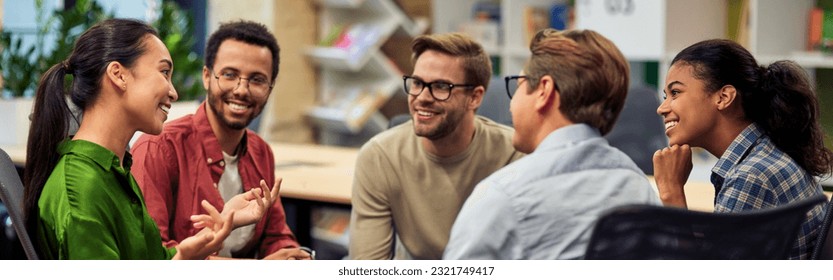 Creating success. Group of young happy multi racial business people communicating and sharing ideas while working together in the modern office - Shutterstock ID 2321749417