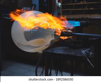 Creating traditional glass Art with Hot Torch and glassblowing pipe.  Creating the heavy glass bowl by traditional method - Powered by Shutterstock