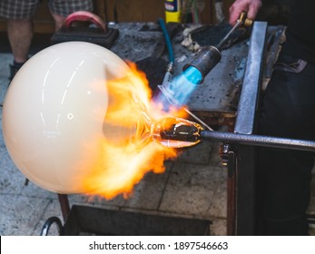 Creating traditional glass Art with Hot Torch and glassblowing pipe.  Creating the heavy glass bowl by traditional method - Powered by Shutterstock