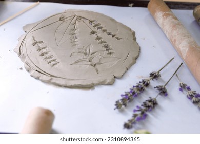 Creation of stencil ceramics with flowers and leaves of lavender and other plants by pressing on the table