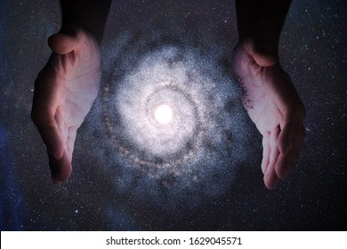 Creationism concept. Hands of God are creating Galaxy in universe.