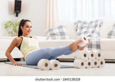 Creative Abs Workout Of A Beautiful Brunette Making A Toilet Paper Pyramid With Her Feet In The Air.