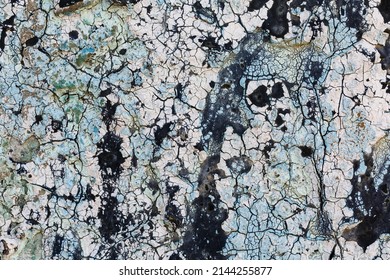 Creative abstract background of decayed cracked bitumen. Outdoor natural textured weathered bitumen pattern