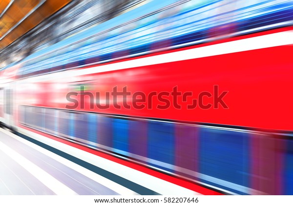 Creative abstract railroad travel and railway\
transportation industrial concept: modern red high speed electric\
passenger commuter double deck train at station platform with\
motion blur effect