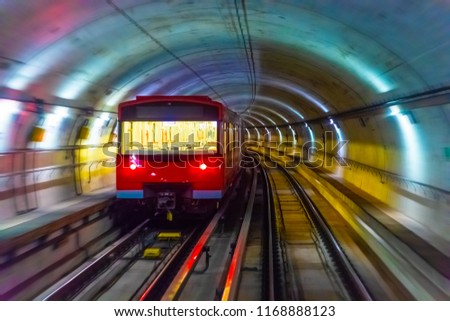 Creative abstract urban city transporation transit technology industrial business concept: red metro train in subway underground tunnel station platform with motion blur effect