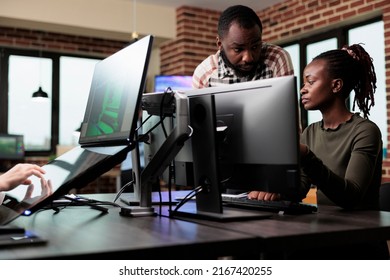 Creative african american office workers discussing about 3D project development progress. Diverse colleagues conversating about professional digital art while sitting at desk in workspace.
