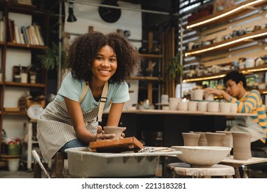 Creative afro American young woman artist molding clay on pottery wheel, Workshop in ceramic studio, clay making of a ceramic pot on the pottery wheel, hobby and leisure with pleasure concept - Powered by Shutterstock