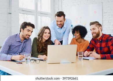 Creative Agency Coworkers Discussing New Project On Laptop