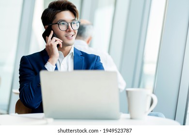 Creative Agency Smart Glasses Asian Male Formal Cloth Conversation With Smartphone Freelance Working With Laptop At Coworking Area Office Space With Freshness With Blur Office Background