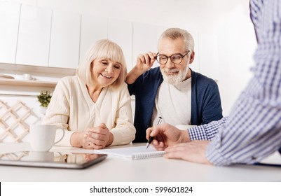 Creative agent showing house layout to aged couple of clients