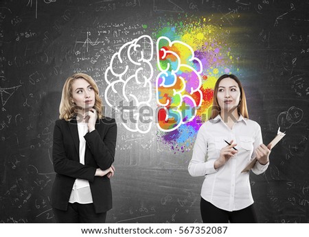 Creative and analytical thinking concept. Asian and european females on chalkboard background with creative brain drawing