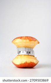 Creative apple core with measuring tape highlights healthy choices and portion control for diet and nutrition