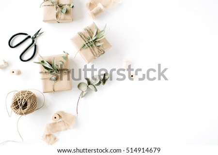 creative arrangement pattern of craft boxes and green branches on white background. flat lay, top view
