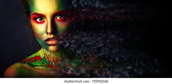 Creative art make up. Closeup cropped studio portrait of young fashion model with bright colorful mix of paint on her face. Color fantasy, artistic makeup. Art processing