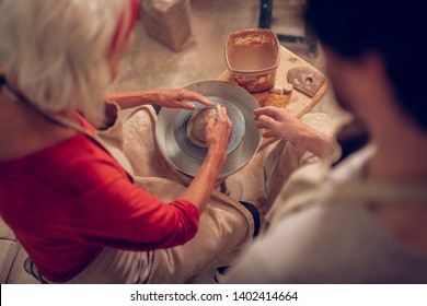 Creative art. Top view of a nice skilled woman creating ceramic dishes while working - Powered by Shutterstock