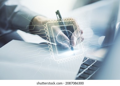 Creative artificial Intelligence concept with human brain hologram and hand writing in notebook on background with laptop. Multiexposure
