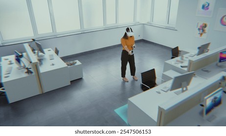 Creative Asian female designer wearing augmented reality headset uses virtual interior design software and controllers to build office room with 3D furniture and equipment. Futuristic VFX animation. - Powered by Shutterstock