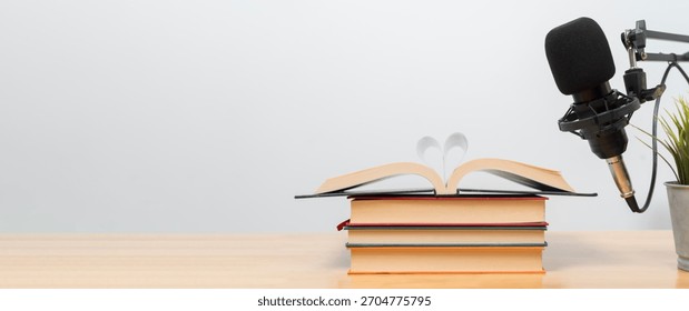 Creative audiobook narration setup featuring an open book with heart shaped pages near a studio microphone, symbolizing storytelling, learning, education, romance and digital audio creation.