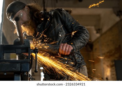 Creative authentic motorcycle workshop redhead bearded brutal biker work with circular saw Sparks fly from hot metal - Powered by Shutterstock