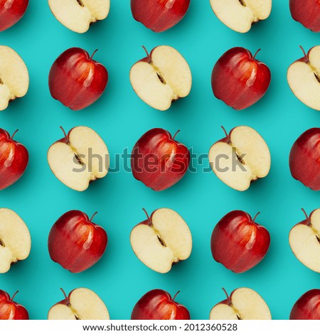 Creative backdrop for wallpaper, ad, offer. Halves and whole red juicy apples arranged over vibrant blue background. Modern artwork.