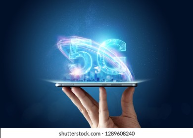 Creative background, male hand holding a phone with a 5G hologram on the background of the city. The concept of 5G network, high-speed mobile Internet, new generation networks. Mixed media.
