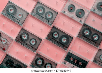 Creative background with old audio cassettes. Collection of audio cassettes in open boxes on a light pink background. View from above.