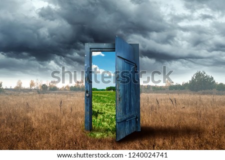 Creative background. Old wooden door, blue color, in the box. Transition to a different climate. The concept of climate change, portal, magic. Copy space.