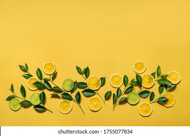 Creative background of summer tropical fruits with leaves, in the form of flowers, lemon, lime on a pastel yellow background. The concept of power. Flat sunbed, top view, copy space