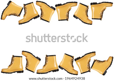 Creative background with yellow rubber boots on white background.Lots of women's rubber boots.Autumn style concept, sale, discounts on seasonal shoes, comfortable clothes.The pattern.Copyspace