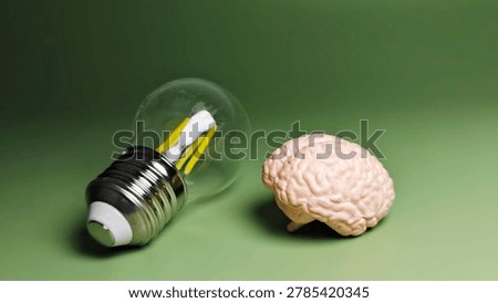 Creative Brain Model and LED Filament Light Bulb on Green Background Representing Innovation Intelligence and Bright Ideas. 