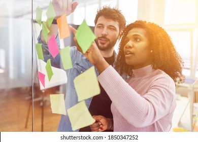 Creative Brainstorming In The Office With Sticky Notes On A Glass Wall