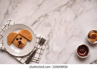 Creative Breakfast For Children. Funny Pancake Food Art. Banana Pancakes In The Form Of Dogs. Copy Space. Top View.