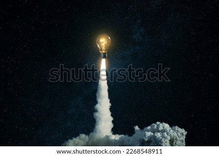 Creative burning light bulb rocket with blast and clouds of smoke successfully takes off into the starry sky. Creative idea, concept. Generation of new thoughts and ideas. Science and technology.